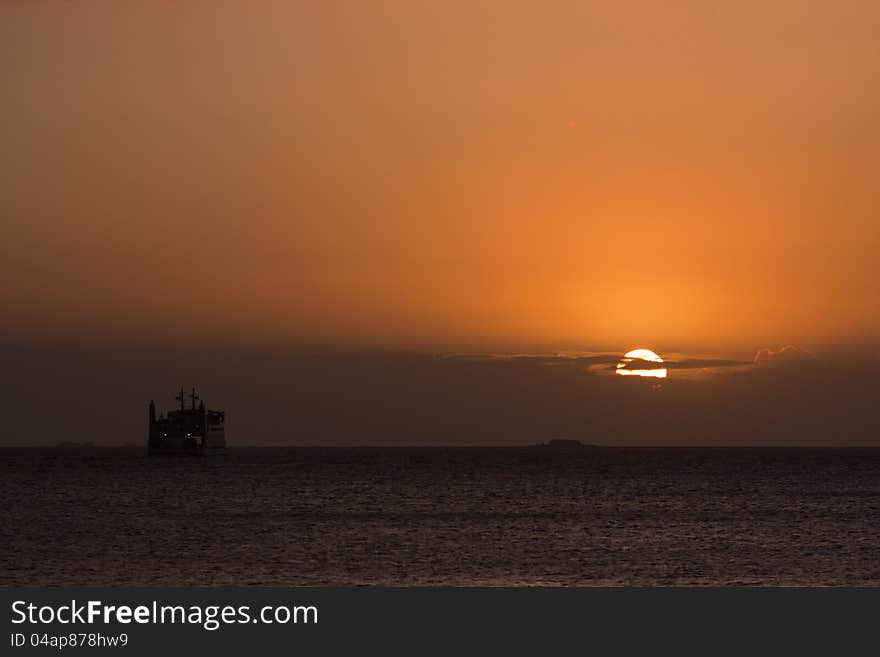 Sunrise over the sea with a ferry