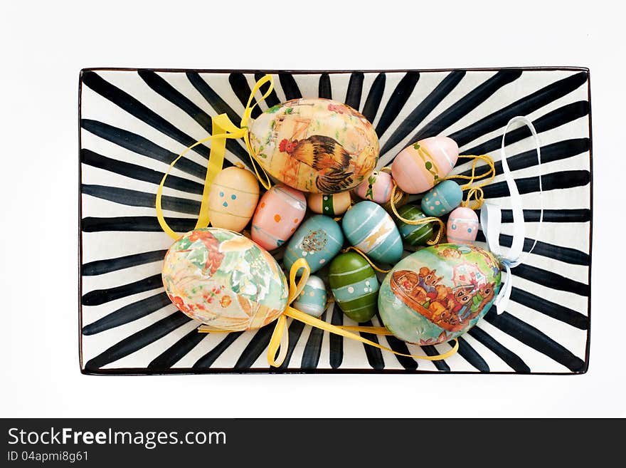 Various colourful easter eggs on a black and white striped plate. Various colourful easter eggs on a black and white striped plate.