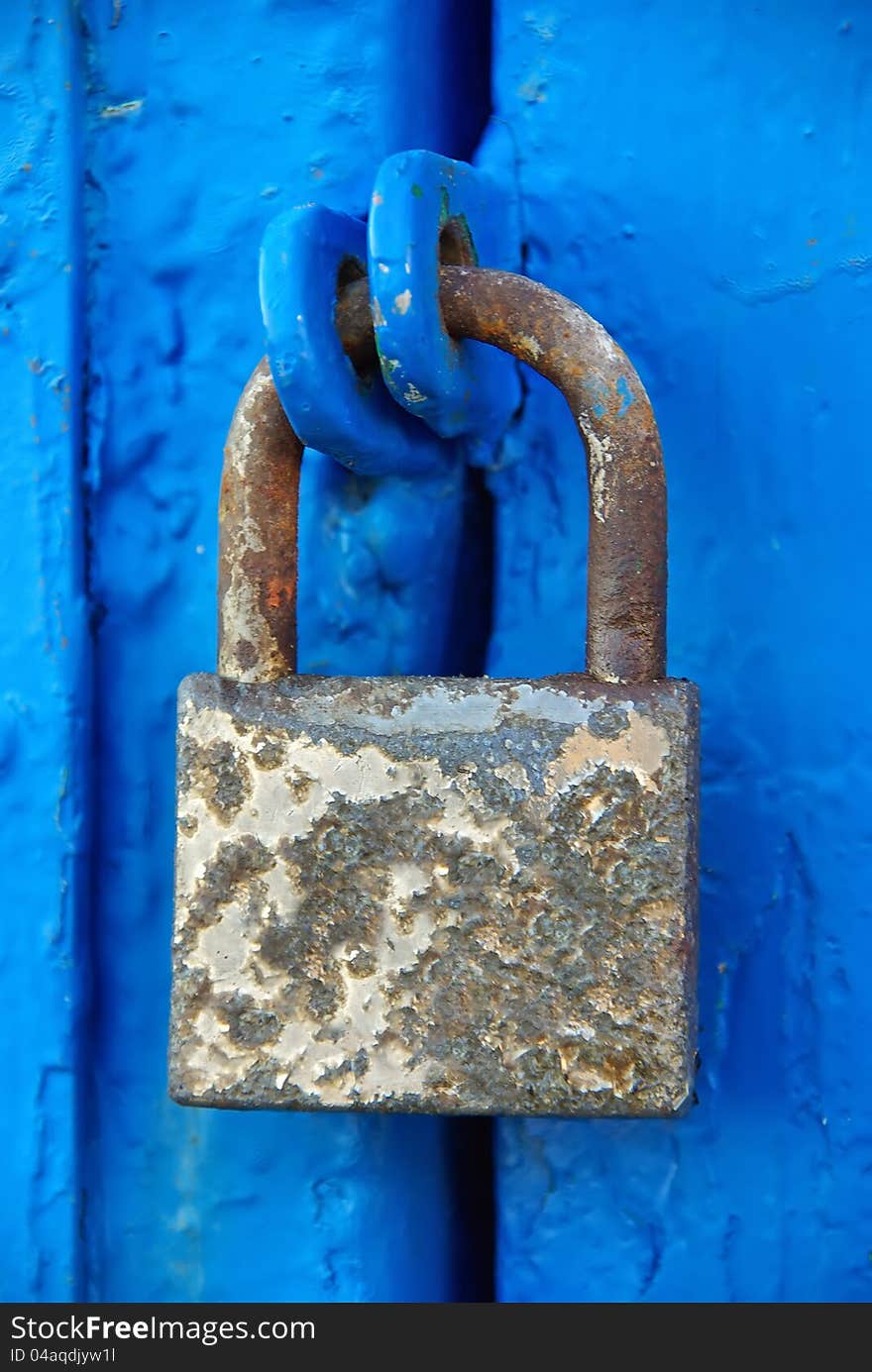 Rusty Padlock on a blue wooden door