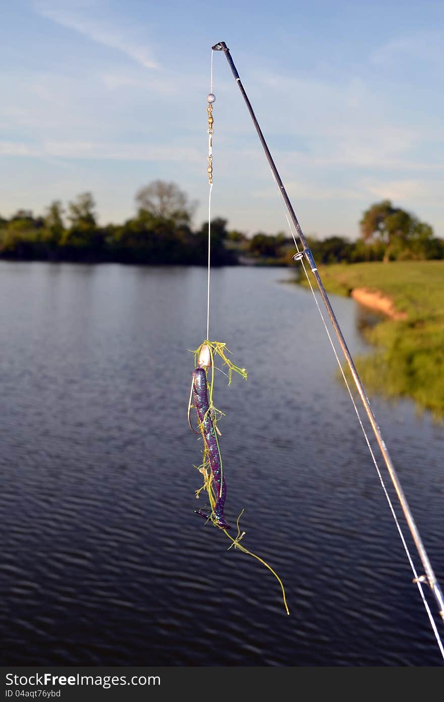 A plastic fishing worm adorned with a lake weed. A plastic fishing worm adorned with a lake weed.