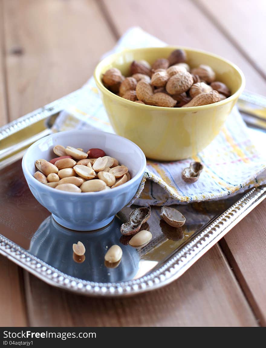 Peanut in a shell and cleared in the bowls on a metal tray