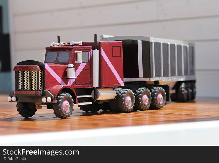 Hand carved wooden semi truck with grain trailer on hardwood floor. Hand carved wooden semi truck with grain trailer on hardwood floor