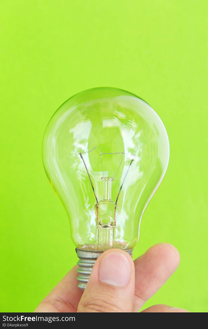 Light blub in hand with green background, eco energy concept