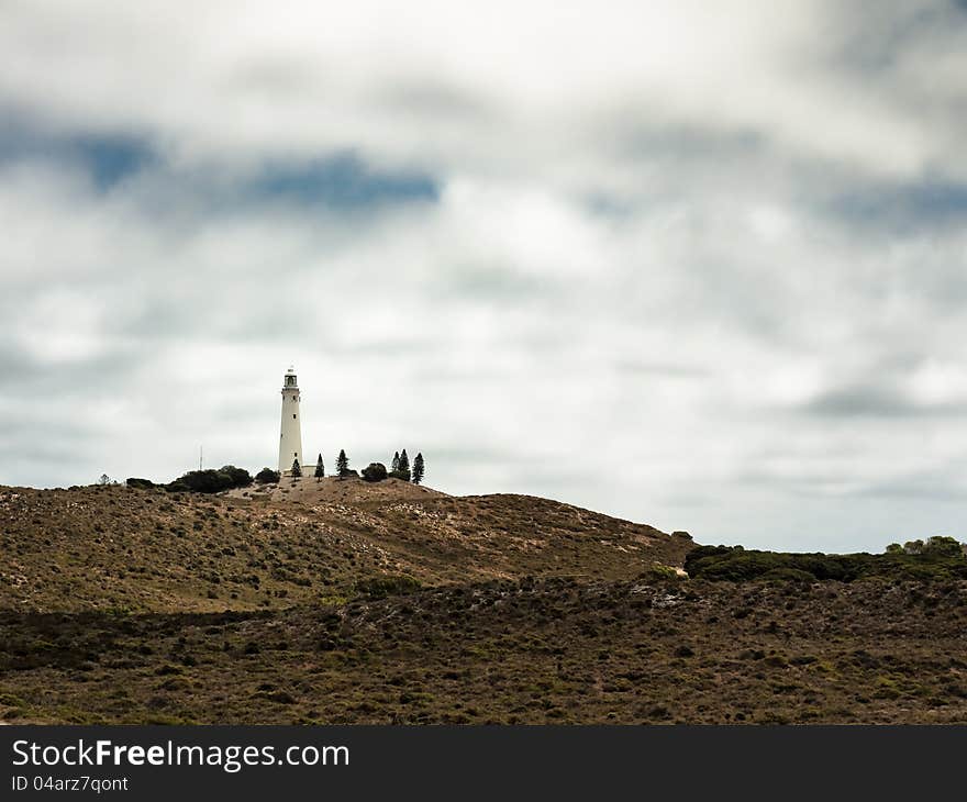 Lighthouse surrounded by vegetation in Rottnest Island, Australia.