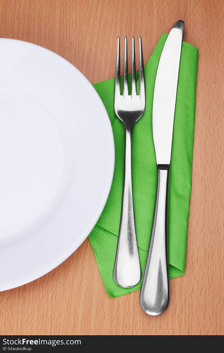 Fork and knife in a green cloth on white