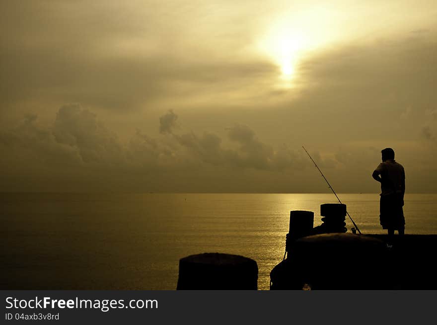 Silhouette fishingman in the sunrise. Silhouette fishingman in the sunrise