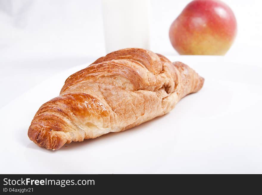 French croissant with apple on light background