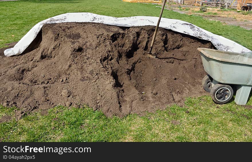 Pile of organic compost with wheelbarrow