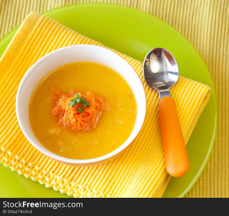 Pumpkin soup from carrots, potatoes and pumpkin decorated with onion