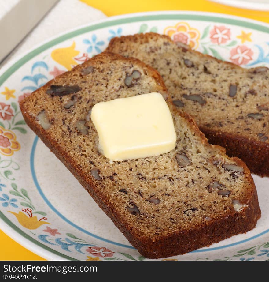 Slice of nut bread with butter on a plate. Slice of nut bread with butter on a plate