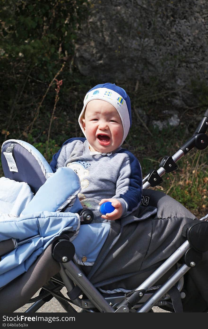 Baby boy rides in the stroller and sing