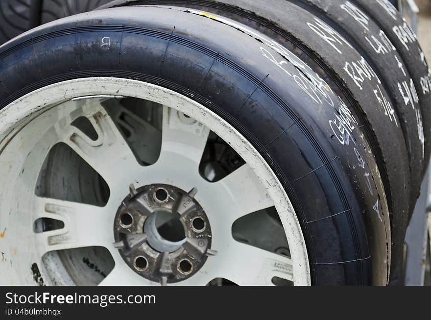 Racing slick tires lined up on a rack. Racing slick tires lined up on a rack