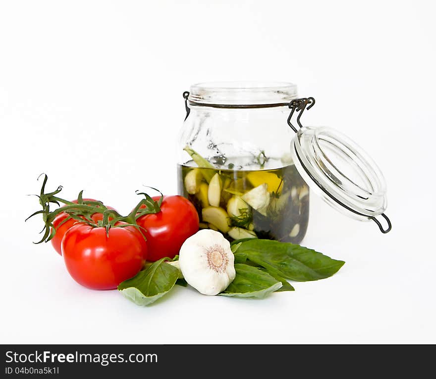 Olive oil in a glass jar with fresh herbs, tomatoes and garlic. Olive oil in a glass jar with fresh herbs, tomatoes and garlic