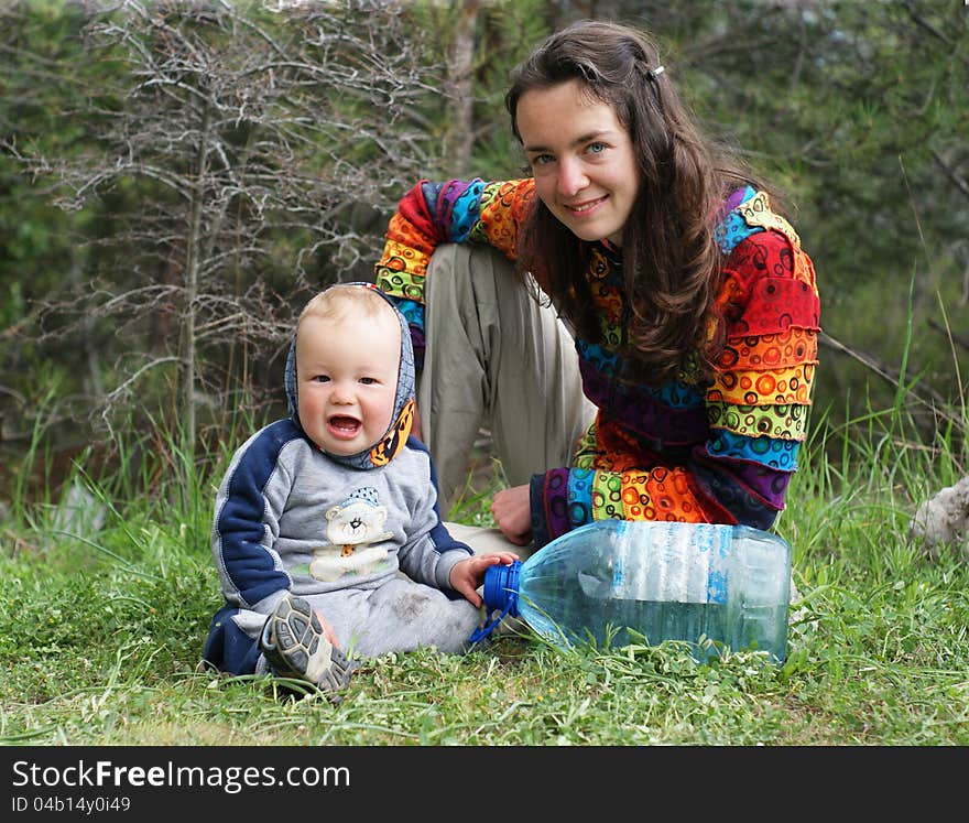 Mother and baby sit on the grass on the nature. Mother and baby sit on the grass on the nature