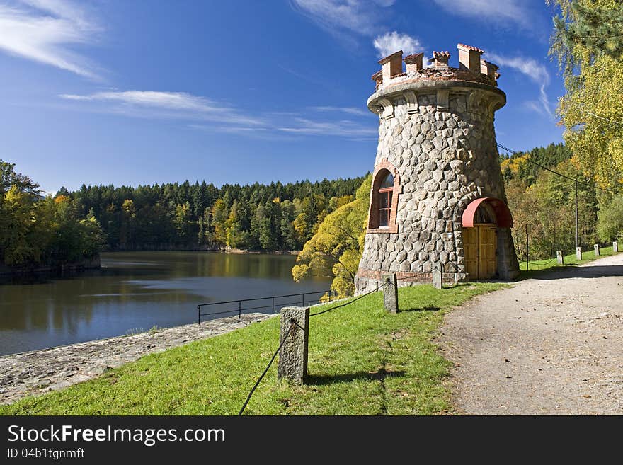 Stone tower of a dirt road and water tank, autumn sunny day with blue sky. Stone tower of a dirt road and water tank, autumn sunny day with blue sky