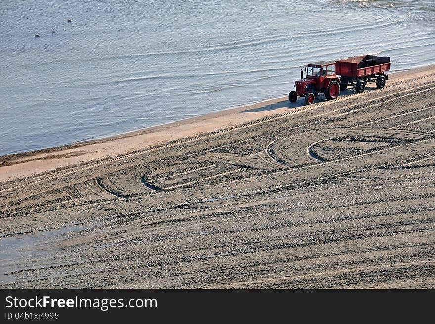 Tractor on the beach and Sunrise over the Black Sea at Mamaia resort near Constanta city in Romania. Tractor on the beach and Sunrise over the Black Sea at Mamaia resort near Constanta city in Romania