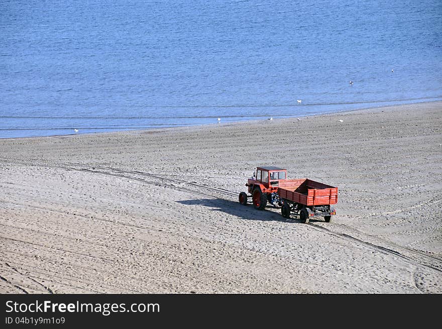 Tractor on the beach and Sunrise over the Black Sea at Mamaia resort near Constanta city in Romania. Tractor on the beach and Sunrise over the Black Sea at Mamaia resort near Constanta city in Romania