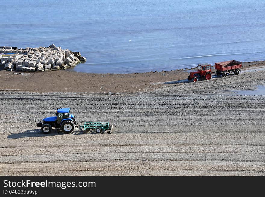 Tractor on the beach and Sunrise over the Black Sea at Mamaia resort near Constanta city in Romania. Tractor on the beach and Sunrise over the Black Sea at Mamaia resort near Constanta city in Romania