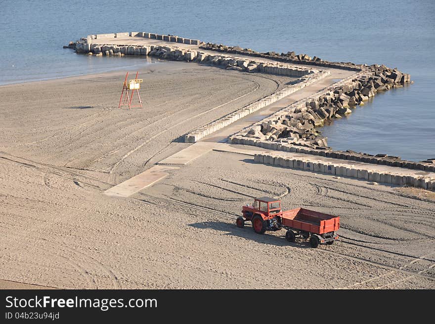 Tractor on the beach and Sunrise over the Black Sea at Mamaia resort near Constanta city in Romania. Tractor on the beach and Sunrise over the Black Sea at Mamaia resort near Constanta city in Romania