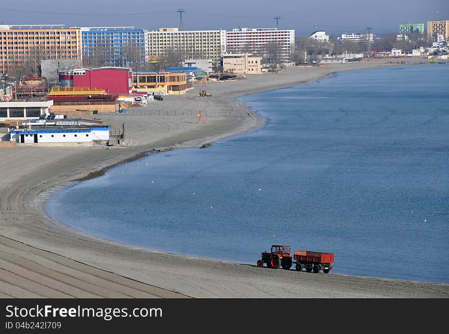 Tractor on the beach and Sunrise over the Black Sea at Mamaia resort near Constanta city in Romania. Tractor on the beach and Sunrise over the Black Sea at Mamaia resort near Constanta city in Romania