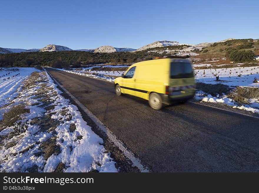 Circulating van road maintenance speeding along a straight road