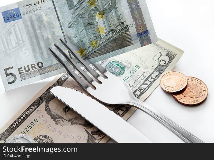 Business concept. Banknotes of dollars, euros with a fork and knife.