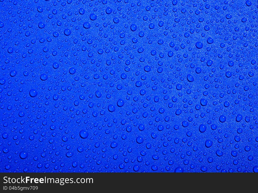 Crystal clear water drops over blue background