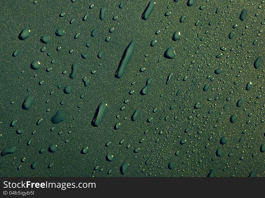 Crystal clear water drops over green background