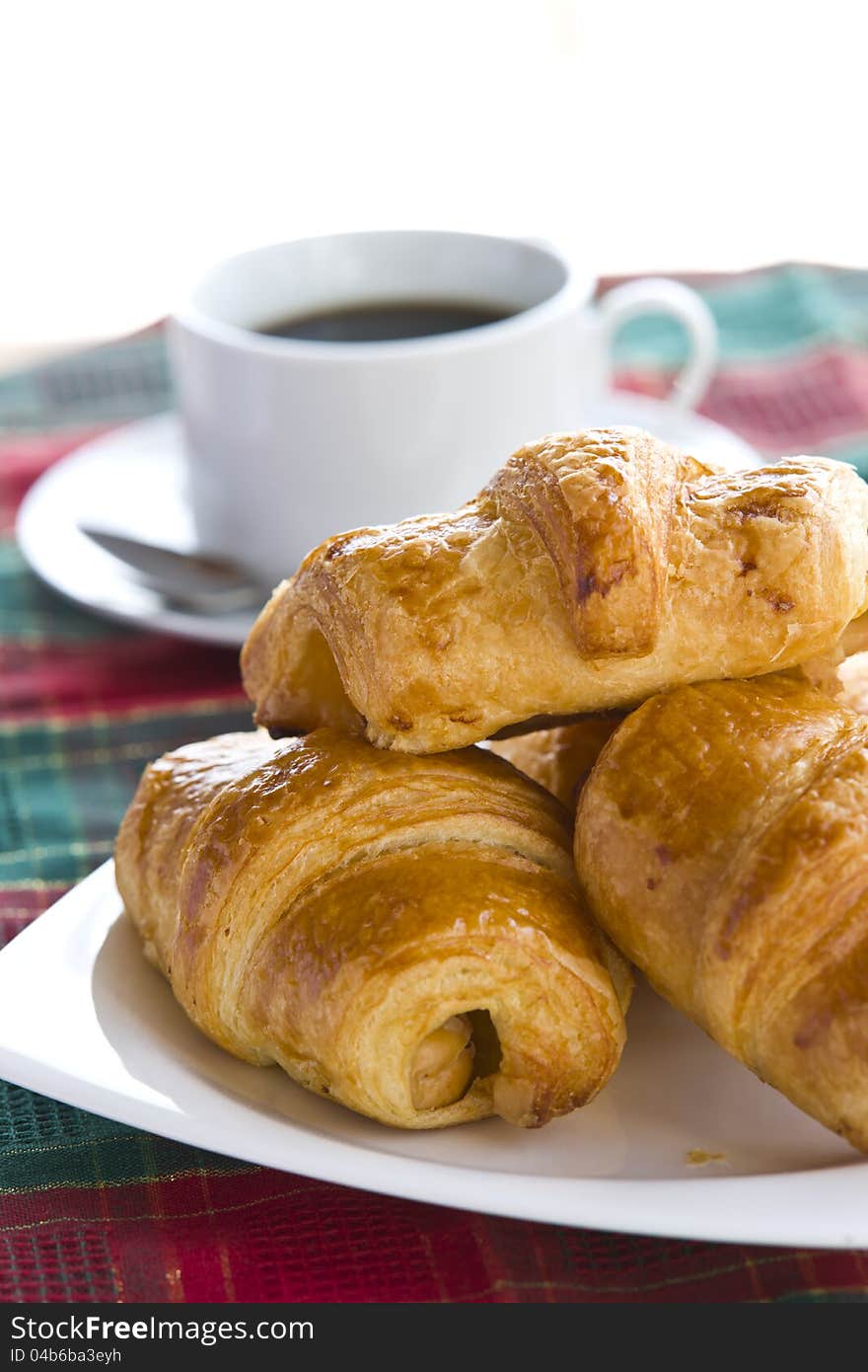 Breakfast with black coffee and croissants