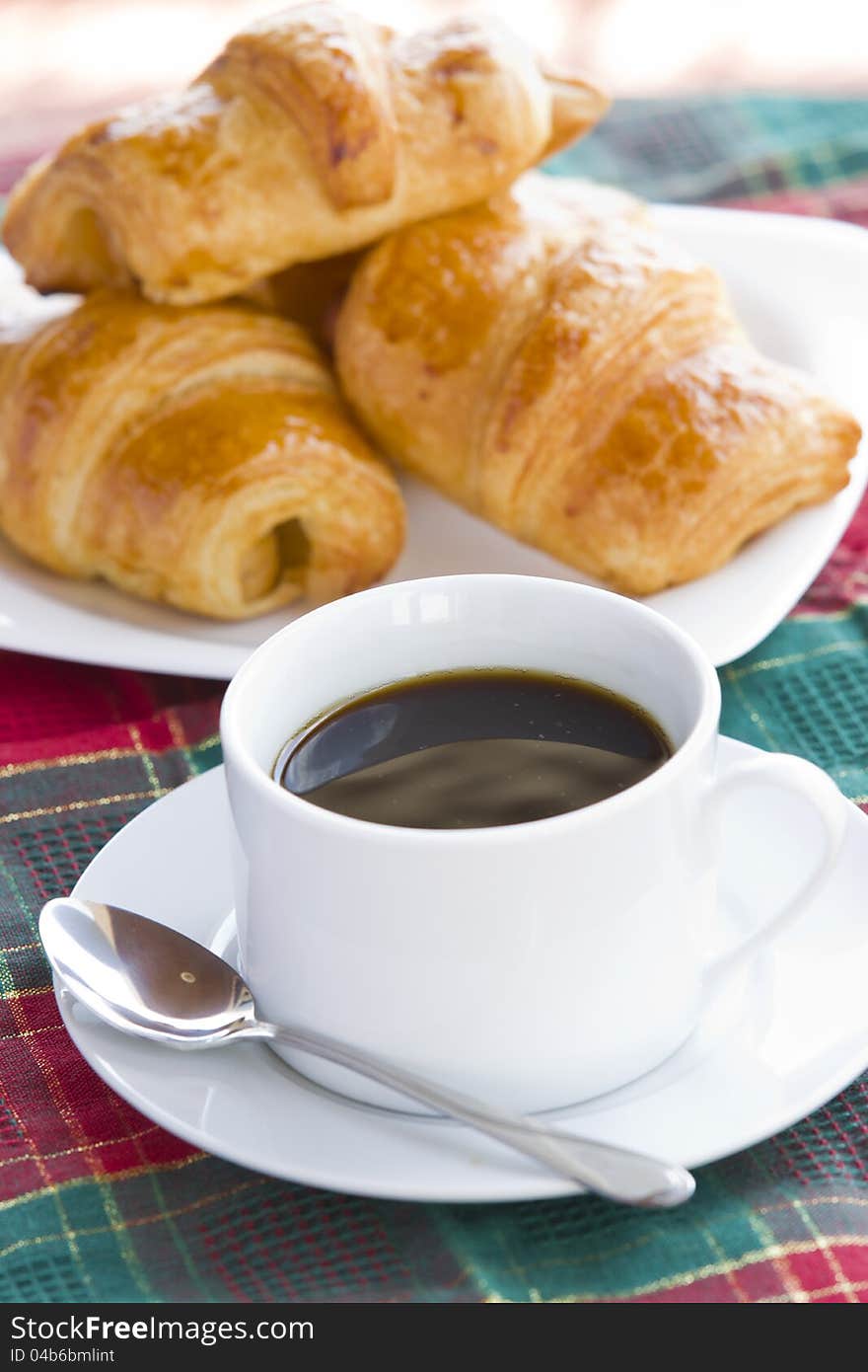 Breakfast with black coffee and croissants