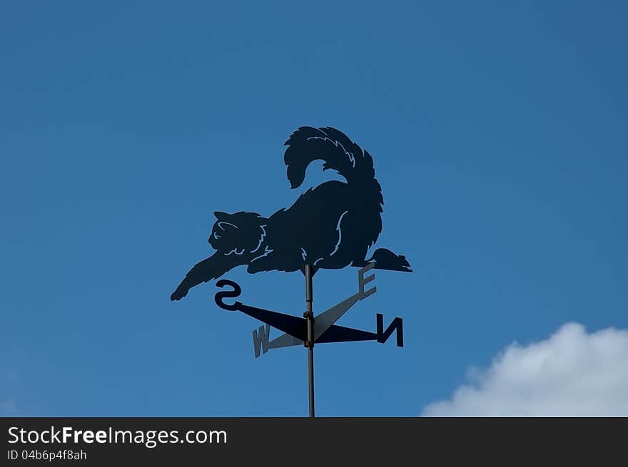 Weathervane with blue sky in the form of a cat and mouse. Weathervane with blue sky in the form of a cat and mouse