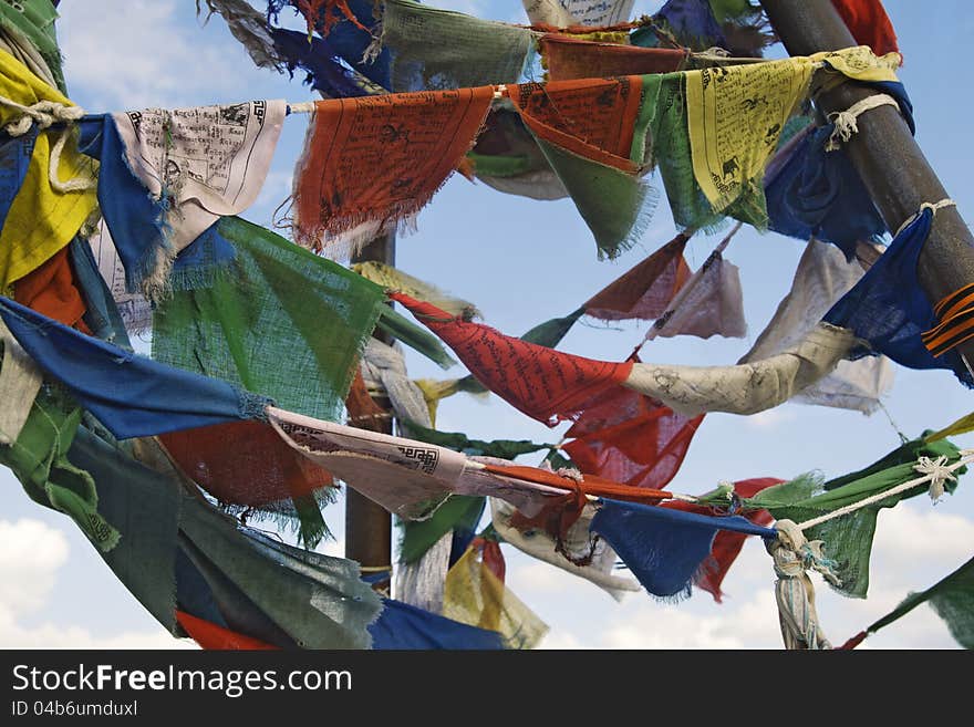 Multicoloured buddhist prayer flags against blue sky