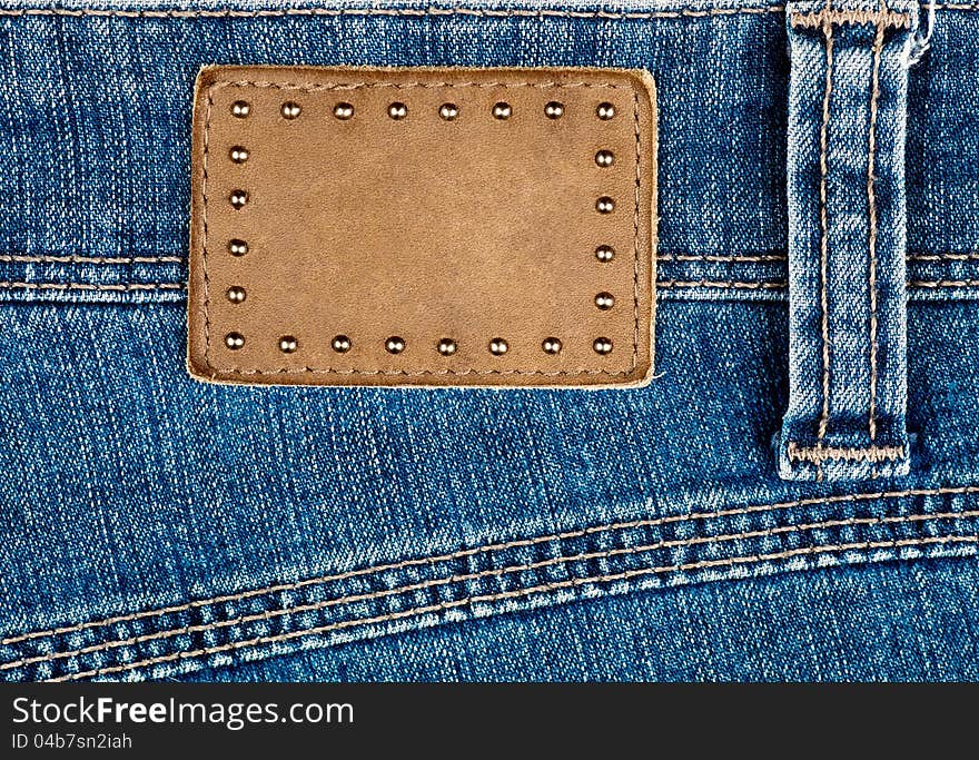 Blank leather jeans label decorated by rivets