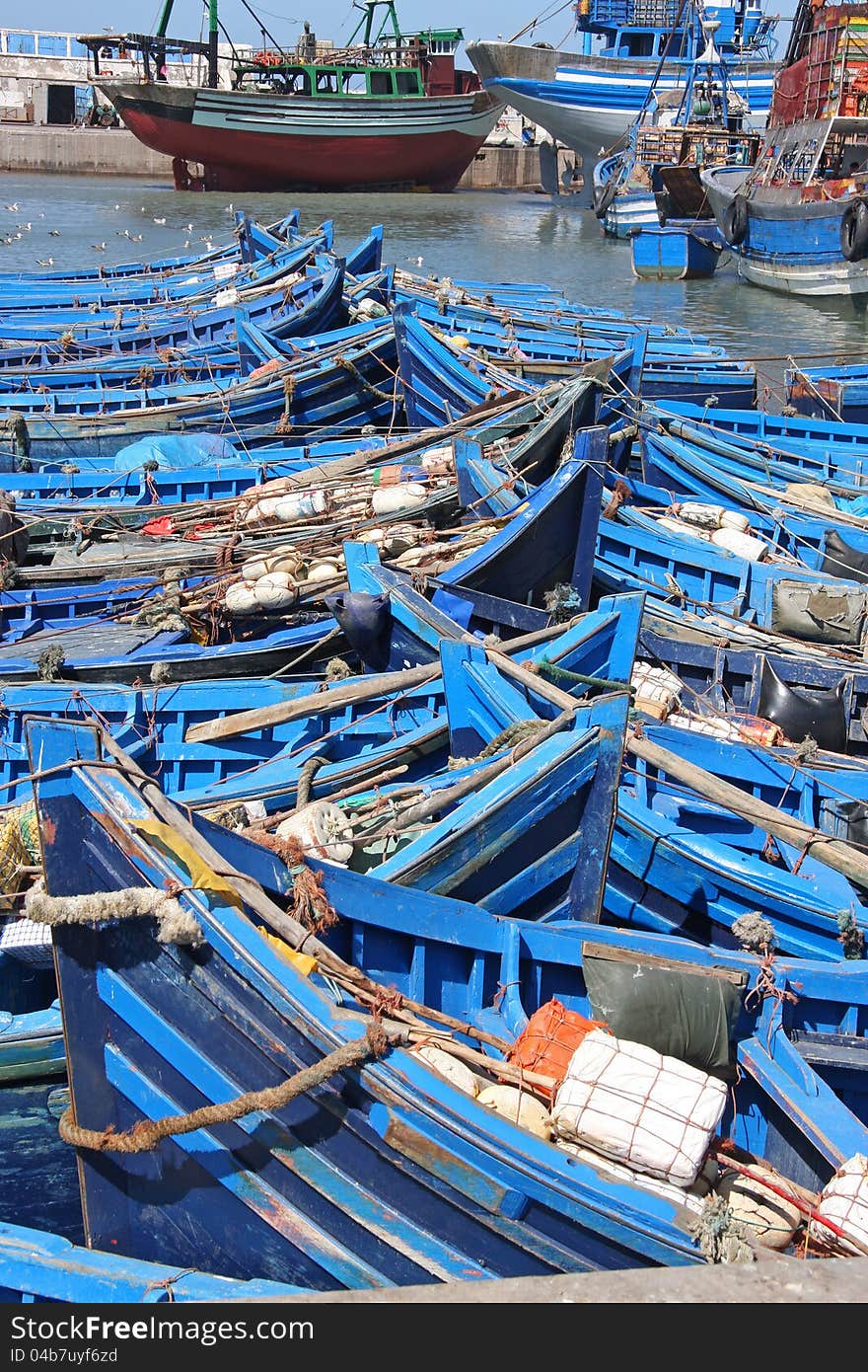 Rows of blue wooden fishing boats in port