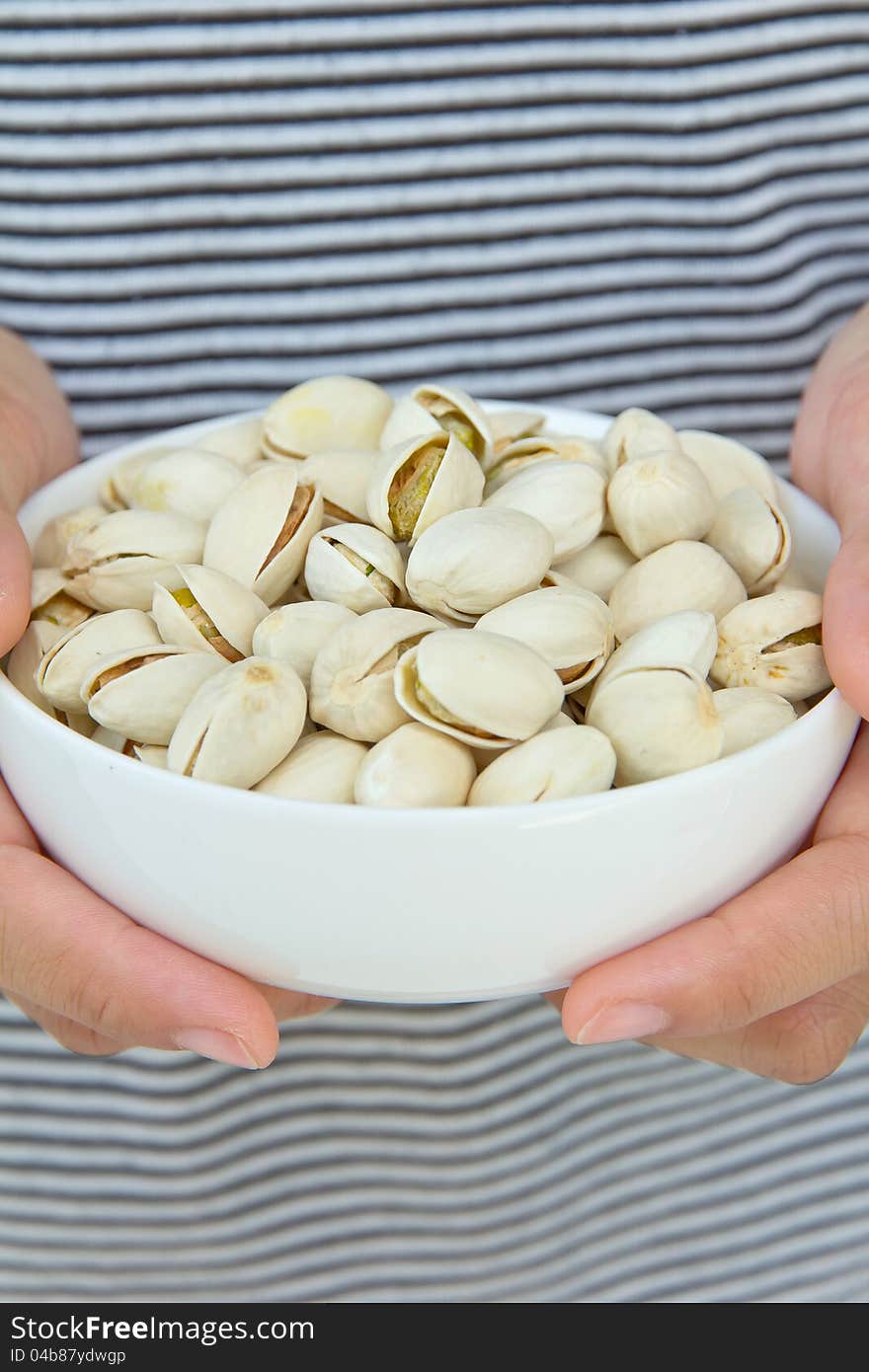 Close up of hand holding pistachios