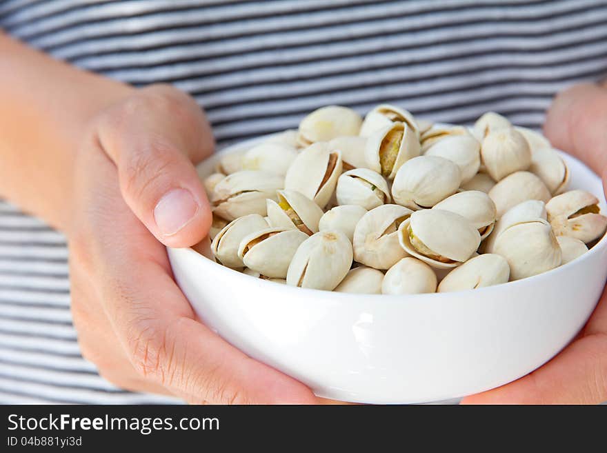 Close up image of hand holding pistachios