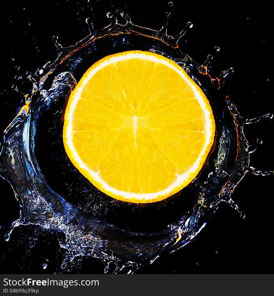 Slice of orange falls into the water.