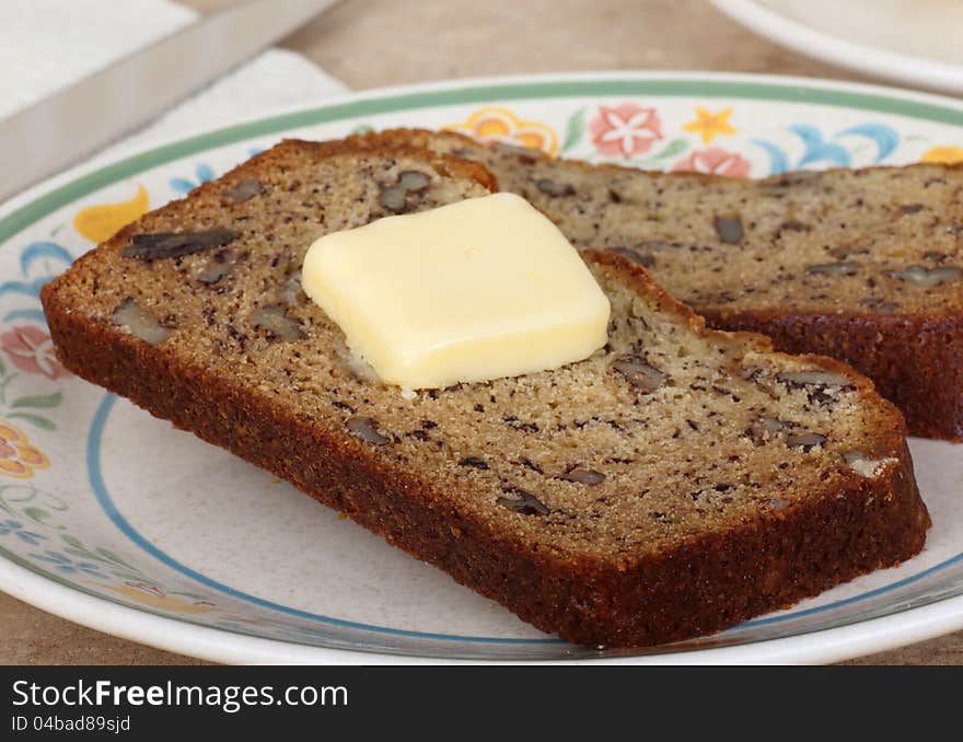 Slices of nut bread with butter on a plate. Slices of nut bread with butter on a plate