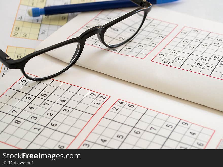 Relax with Sudoku, pencil with eraser rubber and reading glasses