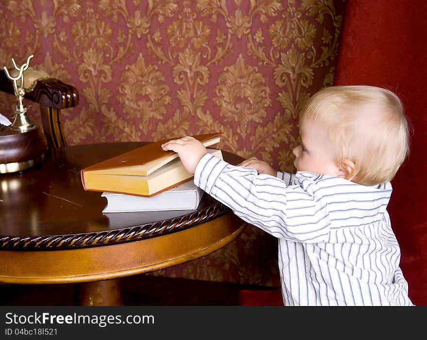 Boy Runs To The Books Lying On A Table