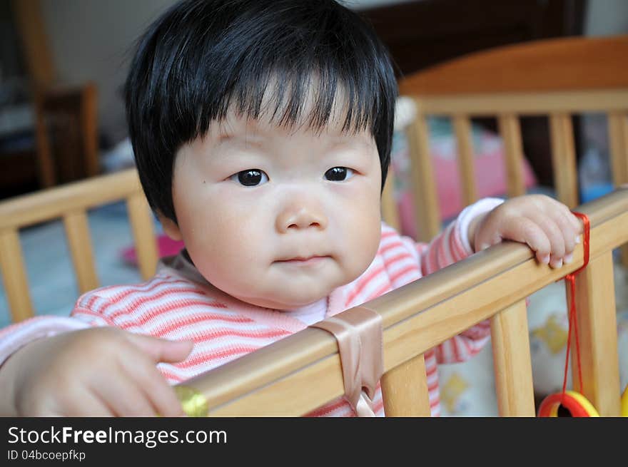 A 11 months chinese Baby girl standing on the bed