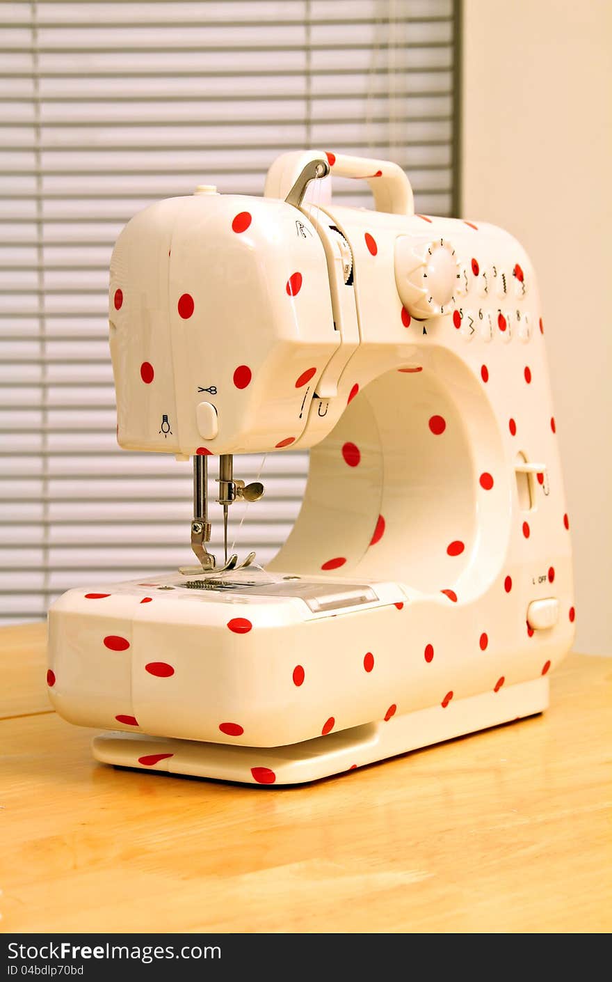 Photo of a modern electric sewing machine with a red polka dot pattern. Photo of a modern electric sewing machine with a red polka dot pattern.