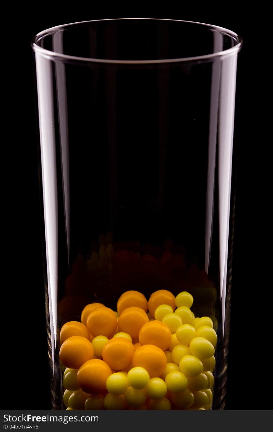 Glass with yellow round pills