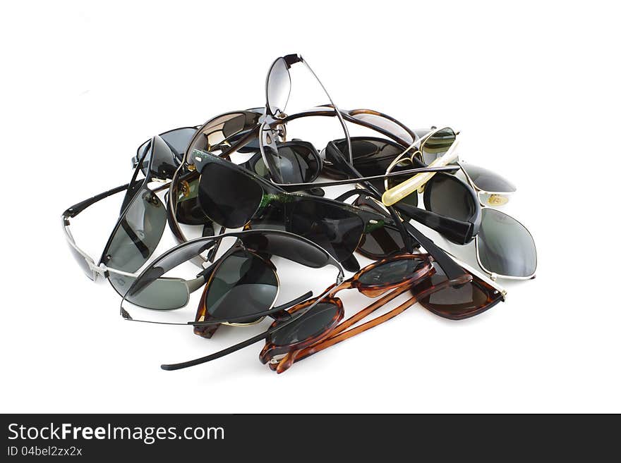 Several pile up sunglasses on white background