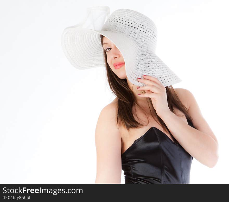 A portrait of a gorgeous young woman, peeking out from under a white hat and smiling coyly at the viewer. A portrait of a gorgeous young woman, peeking out from under a white hat and smiling coyly at the viewer