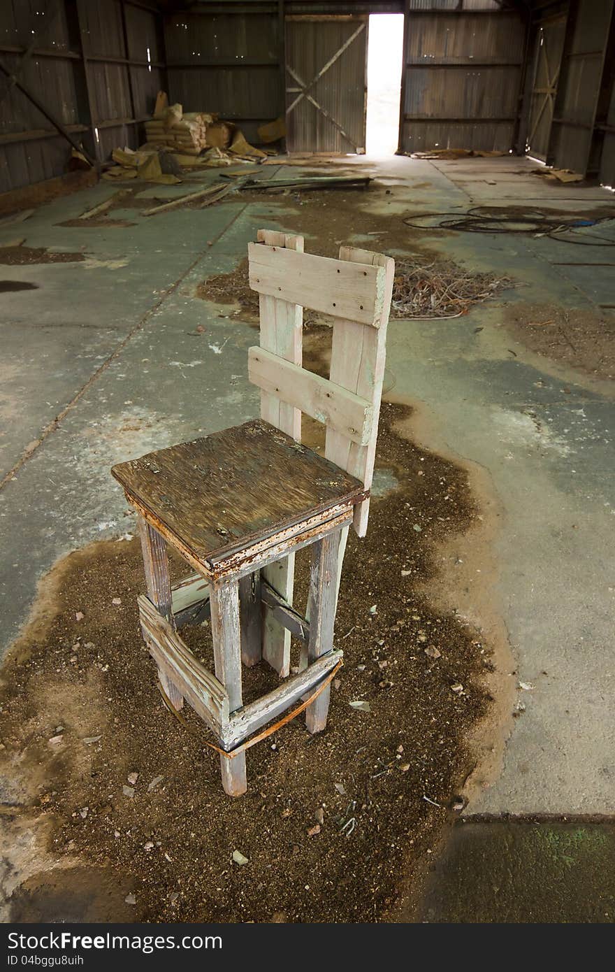 Grungy Old Chair in Warehouse with dirt on floor