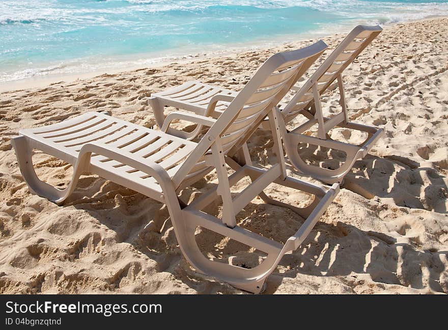 Two sunbathing chairs on the beach