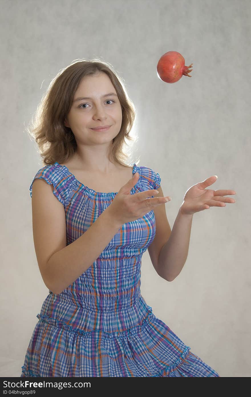 Happy girl throwing up pomegranate. Happy girl throwing up pomegranate