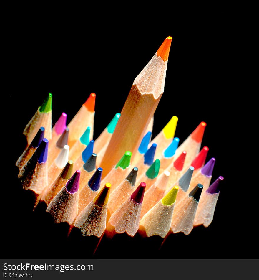 Top view of colored pencils, isolated on a black background