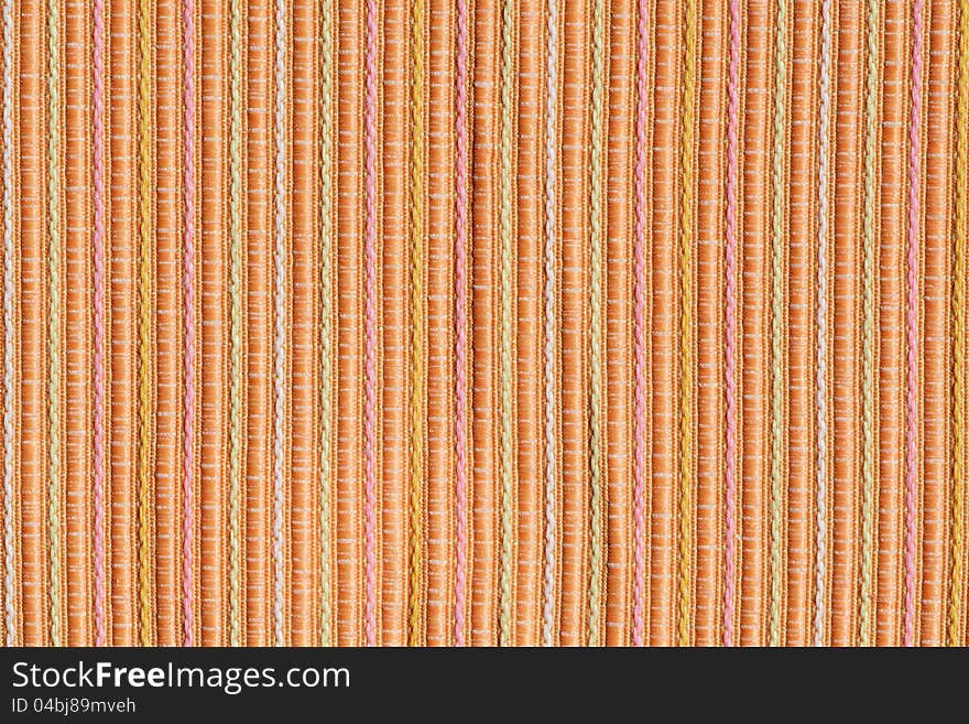 Background of stripy orange and pastel yellow and pink colours fabric. Background of stripy orange and pastel yellow and pink colours fabric